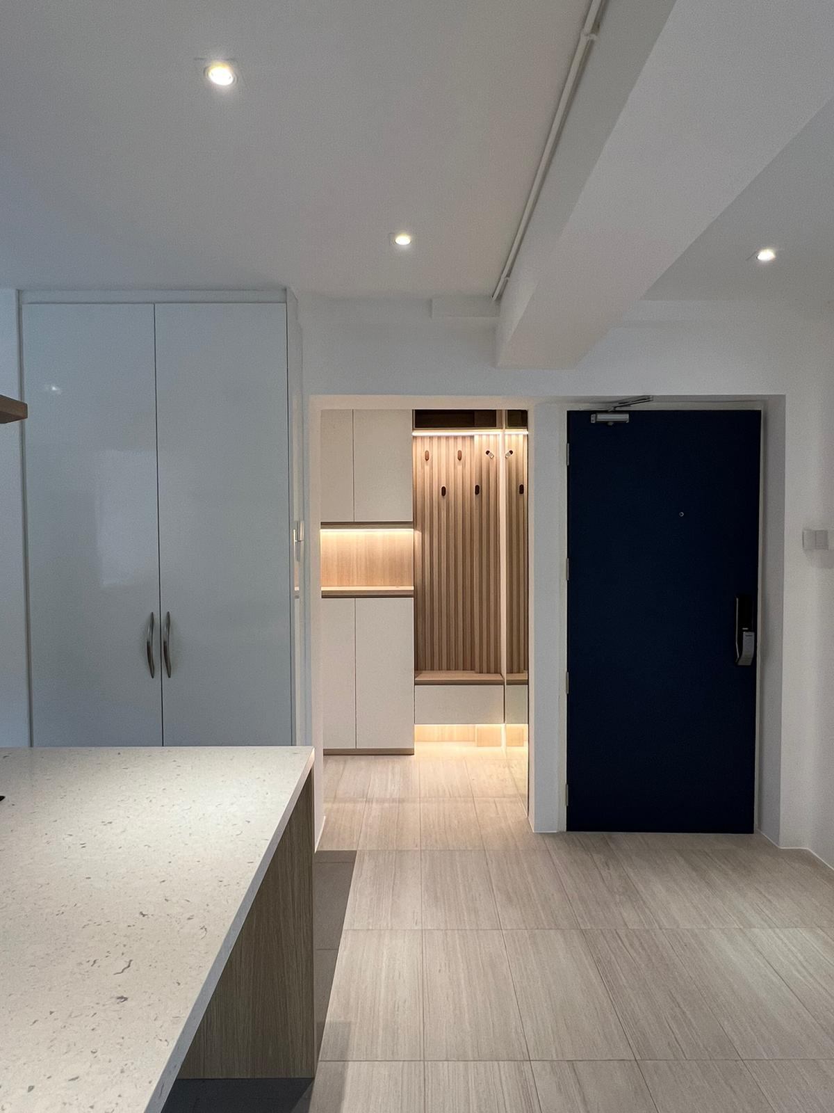View past the kitchen worktop to white tall units, the entry panel and the front door.