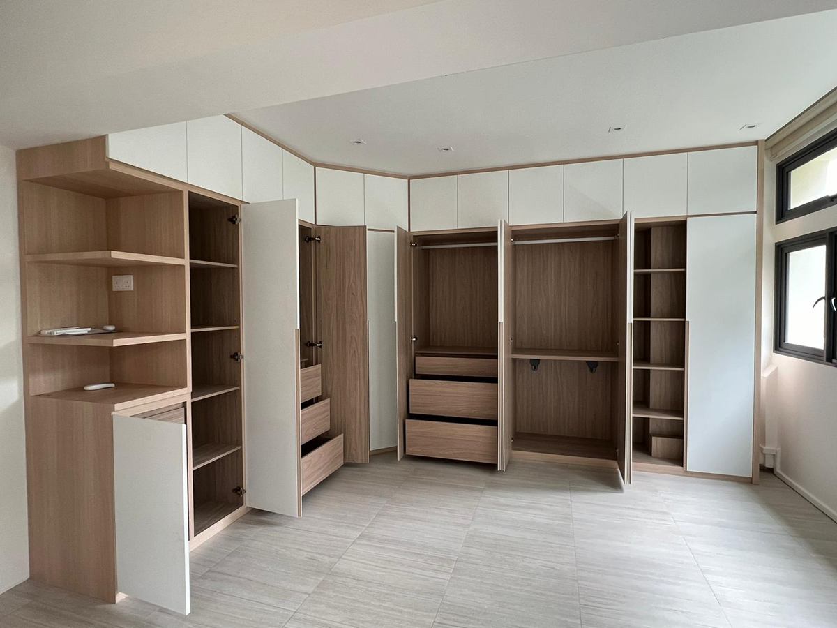 A corner of full-height wardrobes with open shelving and drawers.