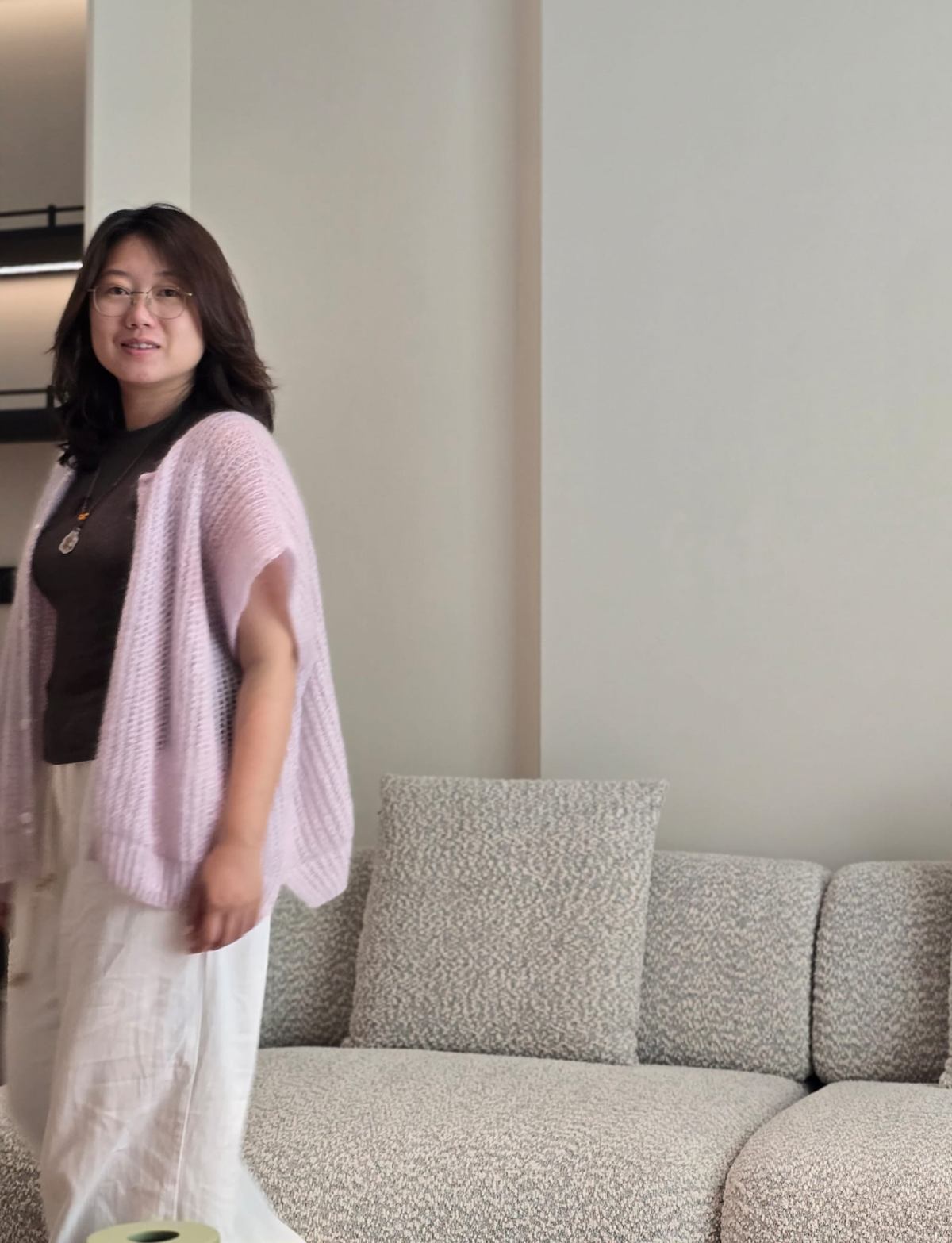 Yifan Wei 站在一张毛圈布沙发旁。